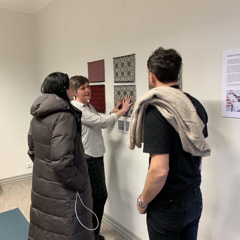 Cornelia Theimer Gardella showing digital weaving samples in the pattern room. Visit of the 3rd Fabricademy Textile Academy Bootcamp in May 2019, co-hosted in Iceland by Distributed Design Market Platform - DDMP, FablabIceland, Nýsköpunarmiðstöð Íslands and the Icelandic Textile Center. Picture: Textile Center.