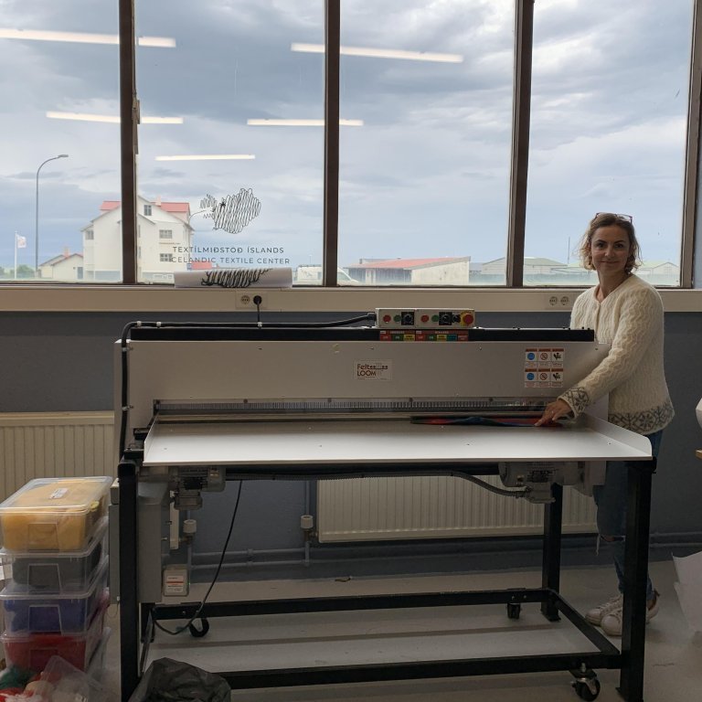 Feltloom Pro 60DM from FeltLOOM. Þessi vél festir saman óspunna ull með því að stinga nálum í ullina þannig að hún loðir saman og úr verður efni. Ull hentar mjög vel sem hráefni til að vinna með í vélinni en hægt er að nota önnur mjúk efni og efnisafganga. Ullarþæfingarvélin er mjög hentug til að vinna efnisprufur sem og búa til einstök listaverk. Stærð vinnuflatar: 150 cm á breidd og eins langt og þú vilt.
//
Our Feltloom Pro 60DM is 150 cm wide, which means that works can be max 150 wide. Length, however, is flexible (artists have been creating works that were approx. 3 meters long). The thickness of the wool or material can be up to 1.5cm, depending on the density of the material. It is suitable for material exploration and large scale work. Wool works the best, though it can handle most fabrics and yarns except for: tightly woven dense fabrics (such as canvas), leather, plastic, or other materials which may break the needles. It can be rented by the hour or day​.